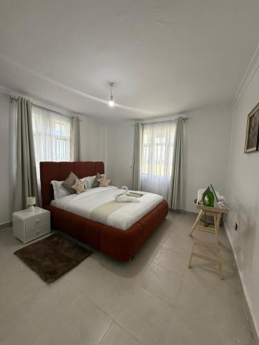 a bedroom with a large bed and a table at Jay Homes -Ultra Modern Naivegas Apartments in Naivasha
