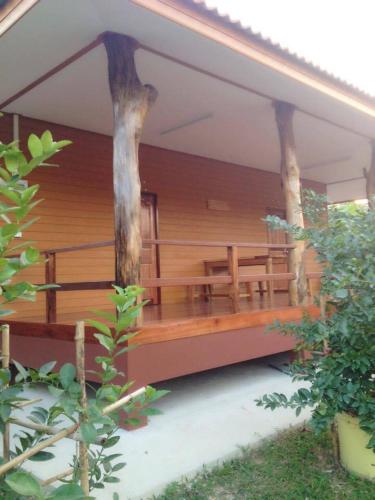 a porch of a house with two trees on it at Baan Suan Kru Kob in Ban Ko Maphang