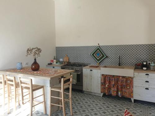 法维尼亚纳Dimora Quattro Vanelle的配有桌子和炉灶的厨房 上层烤箱