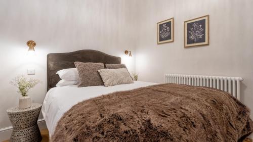 a bedroom with a bed with a brown blanket and pillows at Plas Madoc Lodge in Conwy