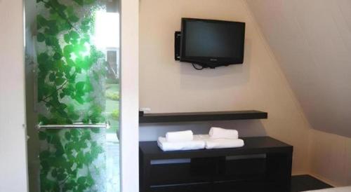 two pictures of a room with a tv and towels at The Park Nangrong Resort in Nang Rong