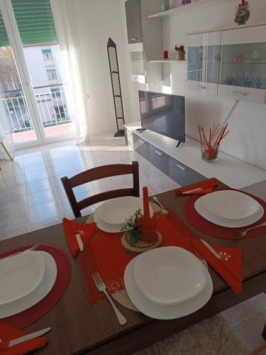 Flori's Home في بيرغامو: طاولة طعام مع صحون بيضاء ومناديل حمراء