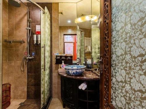 een badkamer met een douche en een wastafel bij Beijing Double Happiness Courtyard Hotel in Beijing