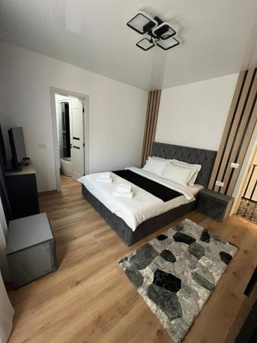 a bedroom with a large bed and a rug at IUNIk in Azuga