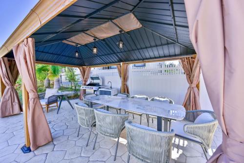 a patio with tables and chairs under a blue roof at Villa MILA ONNA in Onna
