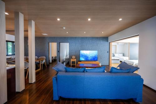 a living room with a blue couch and a bedroom at Villa MILA ONNA in Onna