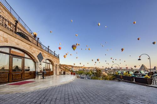a group of hot air balloons in the sky at Cappadocia Inn Cave Hotel in Göreme