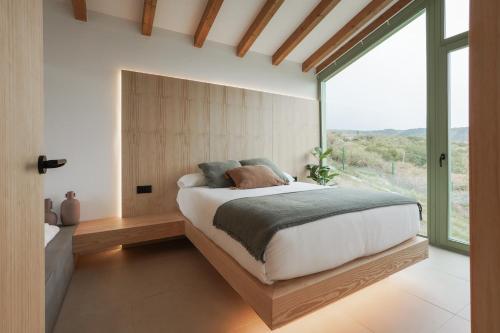 a bedroom with a bed and a large window at Cabañas Ribeira Sacra in Parada del Sil