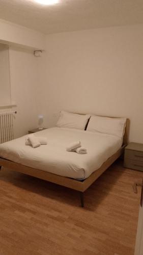 a bedroom with a bed with white sheets and pillows at Valdidentro sweet home in Valdidentro
