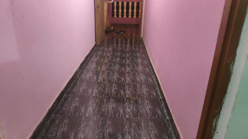 a hallway with a wooden floor and pink walls at Cpdretreathostel in Arambol