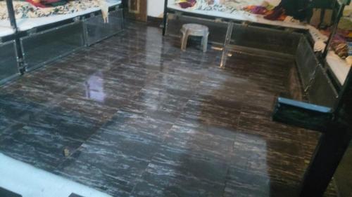 a room with a wooden floor with a table and a chair at Cpdretreathostel in Arambol