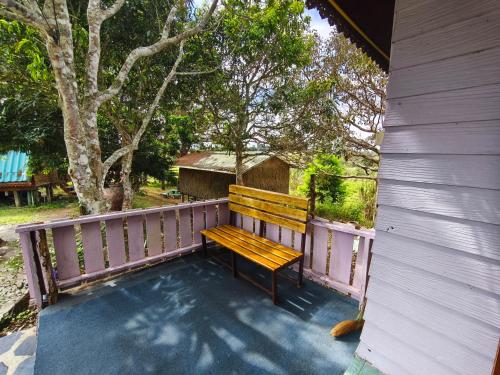 a wooden bench sitting on the porch of a house at เขาค้อ ภูดาว Resort & Camping in Khao Kho