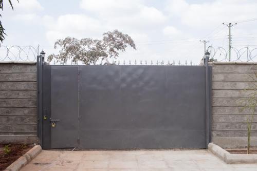 a large black gate in front of a fence at Bethel house ruiru in Ruiru