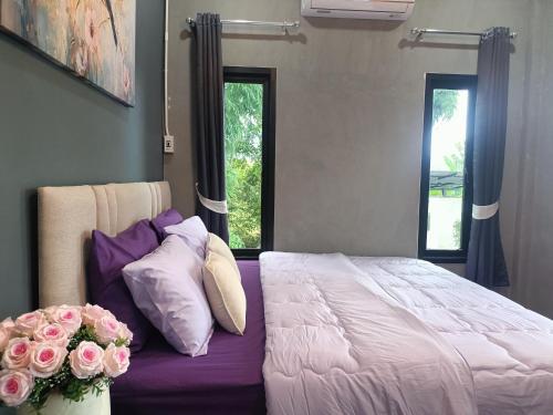 um quarto com uma cama grande com flores em Baan norn nub dao pai em Pai