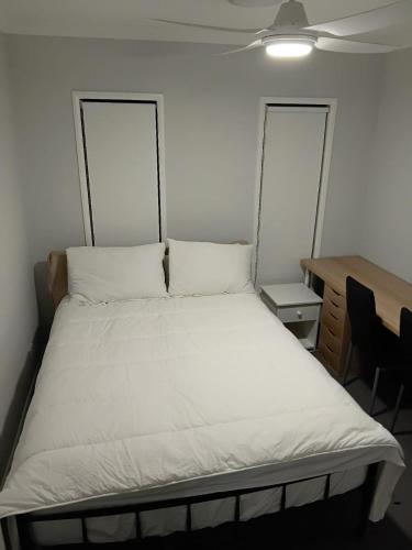 a large bed in a room with a desk at Serene Home in Bahrs Scrub