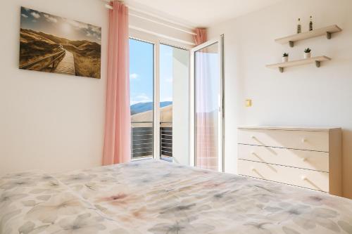 een slaapkamer met een bed met een groot raam bij Sunset Apartments Bohinj in Bohinj