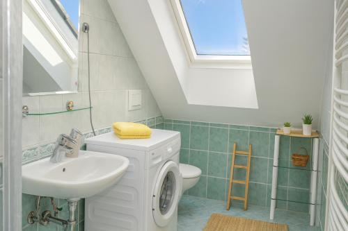 een badkamer met een wastafel en een toilet en een raam bij Sunset Apartments Bohinj in Bohinj