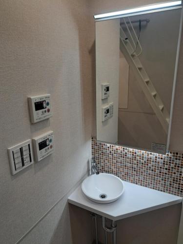 a bathroom with a sink and a mirror at お部屋に露天風呂 自分専用の湯船に新鮮な熱海温泉を入れる贅沢 新築美麗AtamiOnsenApart104 in Atami