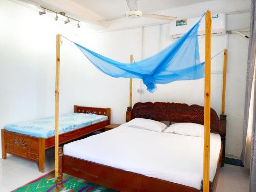 Mamdalis Private Rooms Stonetown في Ngambo: غرفة نوم بسريرين وناموس