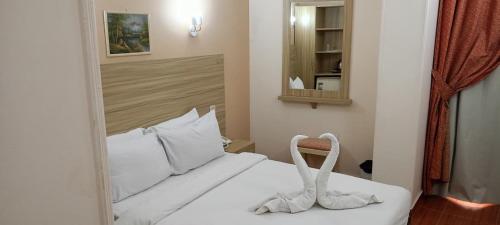 Ένα ή περισσότερα κρεβάτια σε δωμάτιο στο S S Luxor Hotel