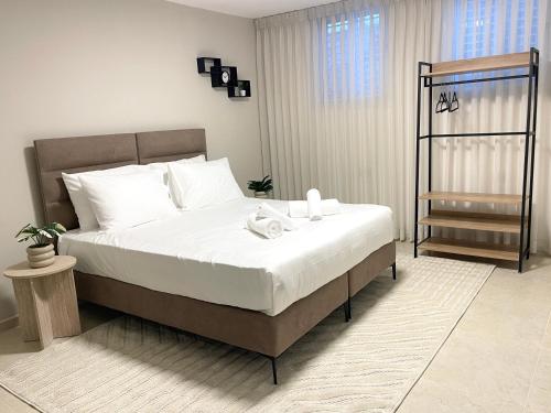 a bedroom with a large bed with white sheets at Ramon Palms in Mitzpe Ramon