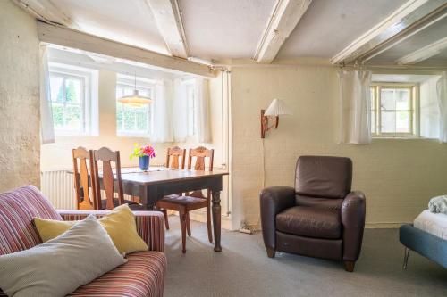 a living room with a couch and a table and chairs at Lyst og rummeligt kælderværelse med egen indgang og parkering in Brabrand