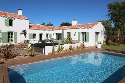 eine Villa mit einem Swimmingpool vor einem Haus in der Unterkunft Magnifique villa Piscine Spa Billard in L'Ile d'Yeu