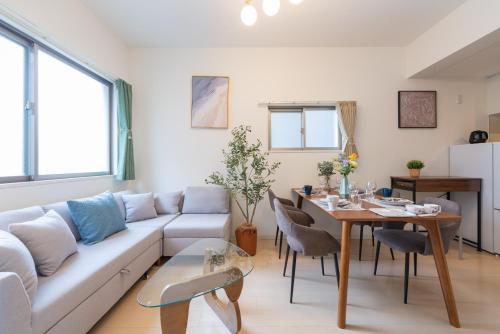 a living room with a white couch and a table at Nagoya Sta 14 min Up to 7 2 Beds and Sofa Bed in Nagoya