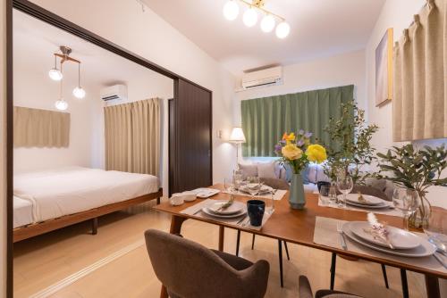 a living room with a table and a bed at Nagoya Sta 14 min Up to 7 2 Beds and Sofa Bed in Nagoya