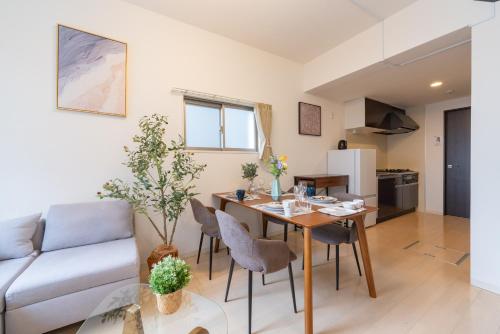 a kitchen and living room with a table and a couch at Nagoya Sta 14 min Up to 7 2 Beds and Sofa Bed in Nagoya