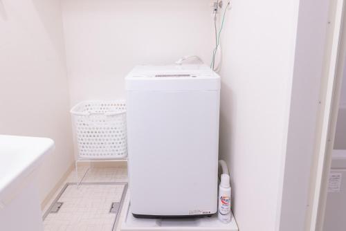a small white refrigerator in a kitchen with a basket at Nagoya Sta 14 min Up to 7 2 Beds and Sofa Bed in Nagoya