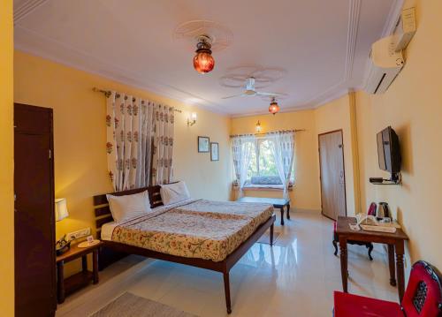 a bedroom with a bed and a tv in it at Chomu Bagh Hotel & Resorts in Chomu in Jaipur