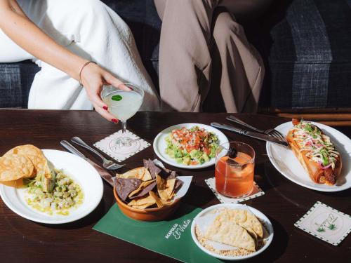 una persona seduta a un tavolo con piatti di cibo di Pullman Quay Grand Sydney Harbour a Sydney