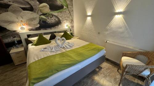 a bedroom with a bed with two swans on it at Hotel Paidion in Braunlage