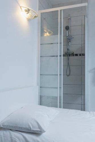 a white bed with a shower in a room at Hôtel Du Bellay in Blois