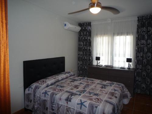 a bedroom with a bed and a ceiling fan at AguaMarina Golf Del Sur in San Miguel de Abona