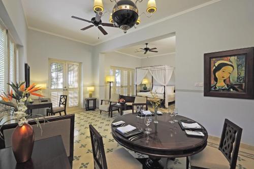 a dining room with a table and a living room at La Veranda Resort Phu Quoc - MGallery in Phu Quoc