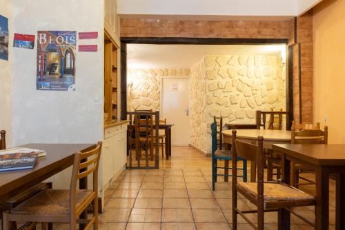 ein Restaurant mit Tischen und Stühlen in einem Raum in der Unterkunft Hôtel Du Bellay in Blois