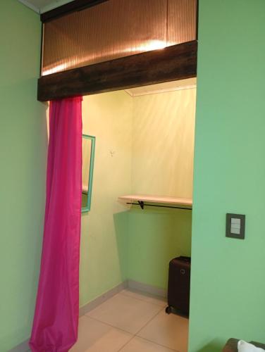 een kamer met een raam met een roze gordijn bij Marias Alojamiento in Garupá