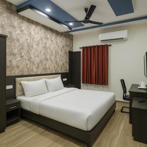 a bedroom with a large white bed and a desk at Hotel Goodwill in Kaithal