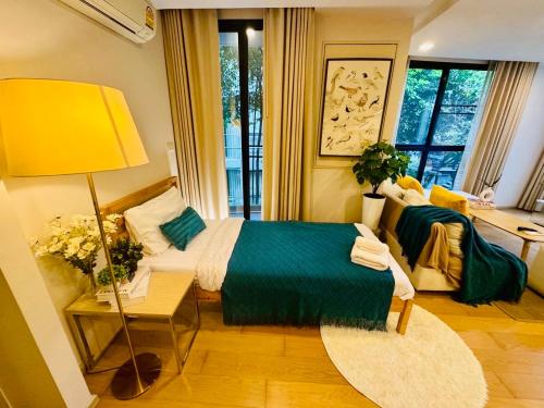 a bedroom with a bed and a yellow lamp at Cozy Spacious 1BR 2Bed GardenView 500m BTS Thonglo, Samitivej, SKV49, Rooftop Pool, Fast 500mbps wifi in Bangkok