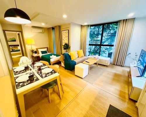 a living room with a couch and a table at Cozy Spacious 1BR 2Bed GardenView 500m BTS Thonglo, Samitivej, SKV49, Rooftop Pool, Fast 500mbps wifi in Bangkok