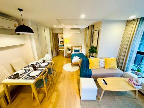 a living room with a couch and a table at Cozy Spacious 1BR 2Bed GardenView 500m BTS Thonglo, Samitivej, SKV49, Rooftop Pool, Fast 500mbps wifi in Bangkok