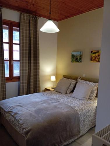 a bedroom with a bed and a window at Golden Hearth Mountain Chalet in Ano Trikala