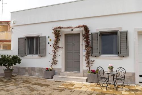 ein weißes Haus mit einem Tisch und Stühlen in der Unterkunft Dimora Giardinelli in Fasano