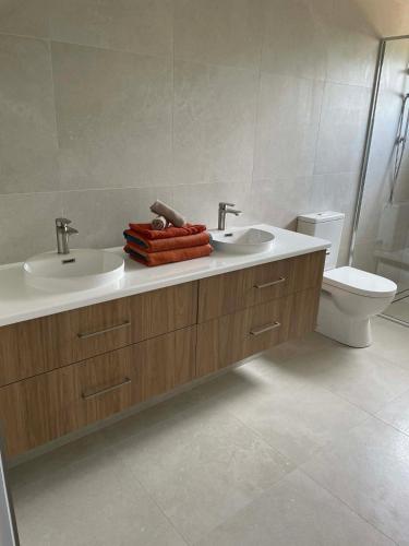 a bathroom with two sinks and a toilet at Coastal Escape in North Coast