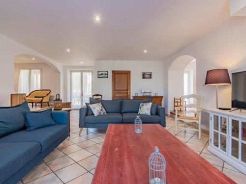 Gite - Domaine Les Peupliers - Lagnes في Lagnes: غرفة معيشة مع أرائك زرقاء وطاولة