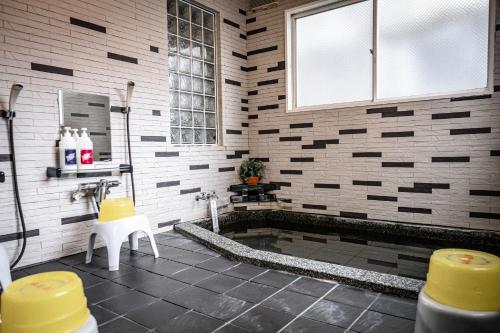 a bathroom with a tub and a sink at Guest house SENWA in Yuzawa