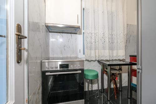 una pequeña cocina con fogones y mesa. en Theodoros Kolokotronis - Alkyoni, en Nauplia