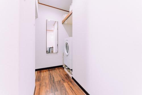 Un pasillo con una lavadora en una pared blanca. en Fukuoka Hakata Stay 1BR with Balcony, TV and Laundry 206, en Wada